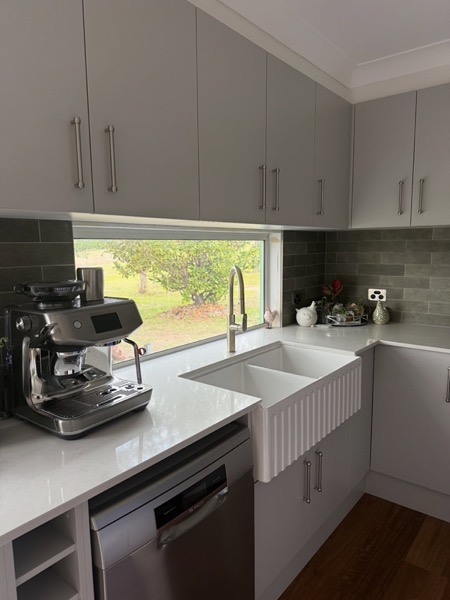 A renovated kitchen with new cabinetry and window above the sink