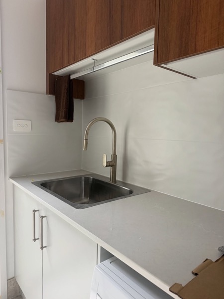 A kitchen sink installed in timber cabinetry