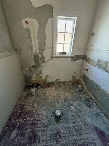 A room mid-renovation with exposed wall framing