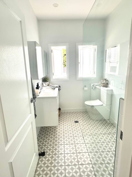 A finished bathroom with tiled floor and two doors